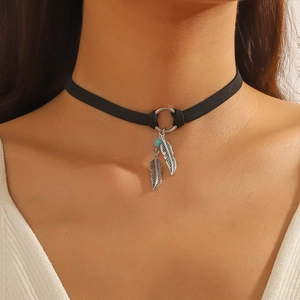 Detail of bohemian choker featuring silver feather pendant and turquoise bead on black band