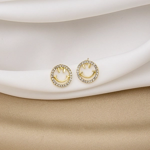 Close-up of gold-tone smiley face stud earrings with sparkling white cubic zirconia stones