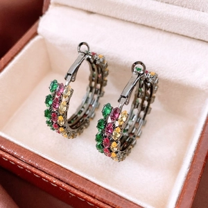 Close-up of vintage oval drop earrings with multi-color rhinestones on a jewelry box