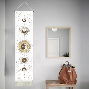 Vertical bohemian sun and moon tapestry with gold accents and tassels hanging on a wall