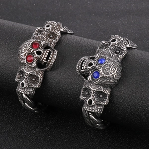 Détail macro du bracelet punk tête de mort avec gravures et yeux en pierre rouge