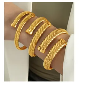 Detail of a layered golden spiral spring bracelet showing its modern metallic texture