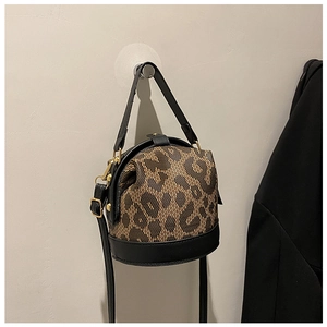 Detail of trendy bucket bag showing leopard print fabric and black leather trim