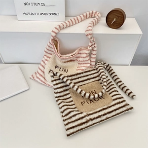 Détail de sacs fourre-tout rayés en peluche avec texture douce et broderie décorative