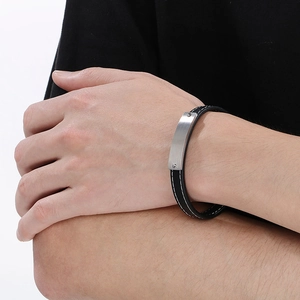 Close-up of black leather bracelet featuring a brushed silver metal bar on a male wrist