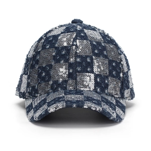 Detail of distressed denim baseball cap featuring shiny silver sequin checkerboard patterns