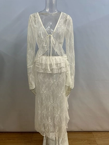 Dettaglio del tessuto in pizzo floreale bianco sul set top con scollo a V e gonna a balze