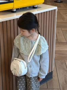 Toddler white round crossbody bag with bow detail paired with casual knit outfit