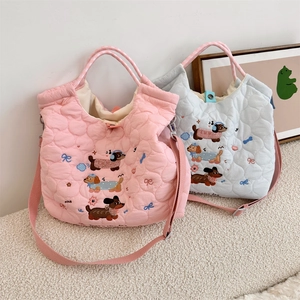 Close-up of quilted tote bags featuring cute dachshund embroidery and magnetic snap closure