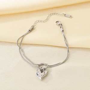 Macro shot of silver stainless steel double-layer snake chain with heart charm