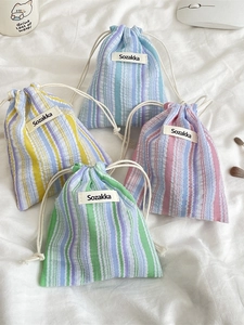 Vertical striped drawstring pouches in blue, yellow, pink, and green cotton fabric