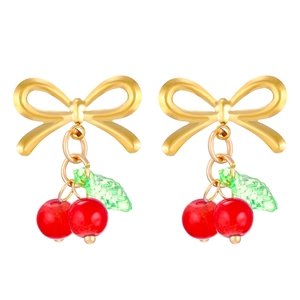 Golden bow earrings with vibrant red cherries and green leaves on white background