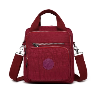 Détail du sac bandoulière en nylon bordeaux avec fermetures éclair et bandoulière