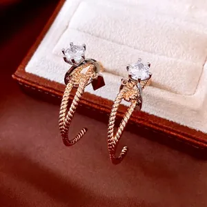 Luxury C-shaped twisted gold earrings with sparkling white cubic zirconia inlay