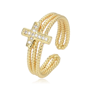 Detail of multi-layered gold cross ring with white zircon stones on white background
