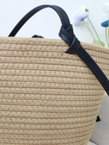 Large khaki woven cotton rope beach tote with black shoulder straps and floral accent