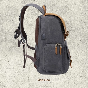 Deep grey canvas camera backpack with leather flaps and a side external USB charging port