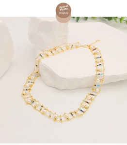 Close-up of double-layer necklace with natural pearls and colored beads on white stone