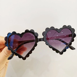 Détail macro de lunettes de soleil en cœur avec bords festonnés et verres dégradés violets