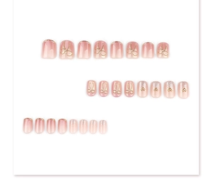 Close-up of short square cat-eye press-on nails with 3D golden bows and heart charms
