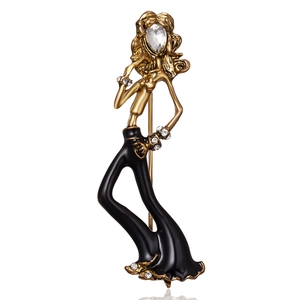 Close-up of elegant ballerina brooch with gold plating, black enamel and rhinestones