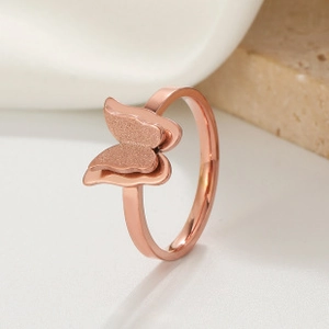 Macro detail of irregular double butterfly ring with rose gold matte and polished finish