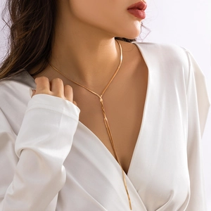 Detail einer eleganten goldenen Schlangenkette in Y-Form mit Quaste an einem Model