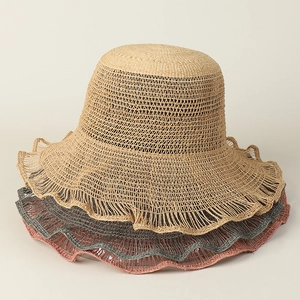 Detail of three raffia sun hats in beige, grey, and pink with wavy brim crochet texture