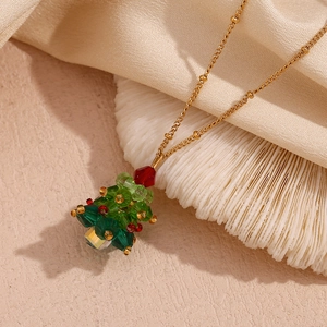 Detail of Christmas tree pendant with green crystals and gold beaded chain necklace
