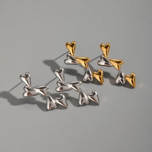 Detail of heart-shaped linked stud earrings in polished gold and silver finishes