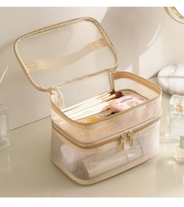 Detail view of double-layer beige mesh toiletry bag with high-quality dual zippers