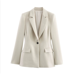 Dettaglio di un blazer beige sfiancato con revers a lancia e chiusura a bottone singolo