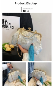 Detail of blue floral embroidery on vintage shell bag with gold clasp and silk tassel