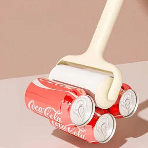 Washable sticky lint roller with extra long handle holding three soda cans to show strength