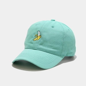 Close-up of cute banana embroidery on a mint green cotton baseball cap with fine texture