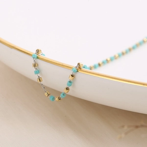 Macro view of bohemian stainless steel chain with turquoise beads and gold accents