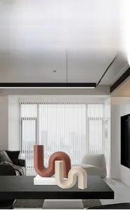 Gros plan de vases en céramique en forme de S avec texture verticale en brique et crème