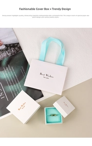 Detailed view of white jewelry gift box set with mint green ribbons and gold ring