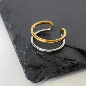 Detail showing two-tone gold and silver layered ring with polished metallic finish