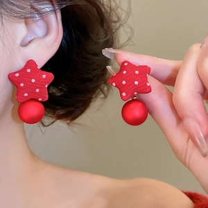 Detail of red fabric star earrings with white polka dots and matte round beads on model