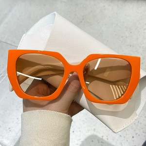 Detail of orange square frame sunglasses with tea lenses and white leather pouch