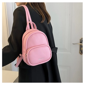 Pink mini PU leather backpack for women shown on a model with a black suit jacket
