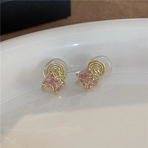 Close-up of pink square zircon earrings with gold bow details and clip-on back