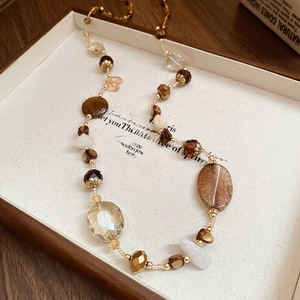 Dettaglio macro della collana vintage con perline ambrate, resina e accenti dorati