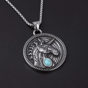 Detail of hip hop unicorn pendant in stainless steel with blue stone on a box chain