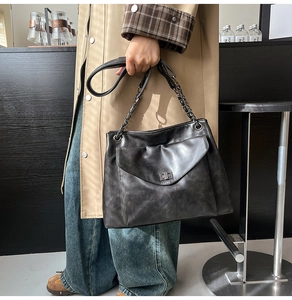 Vista dettagliata della borsa tote grigio antracite con chiusura a scatto e manici a catena