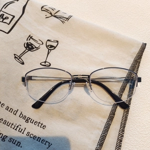 Detail of half-frame black metal glasses resting on vintage French style canvas background