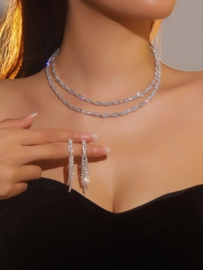Detail of luxury silver bridal jewelry set with sparkling double-layered necklace and earrings
