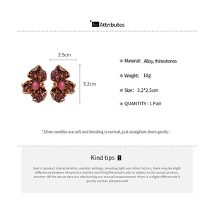 Détails macro des boucles d'oreilles fleurs en résine avec cristaux et épingles en argent