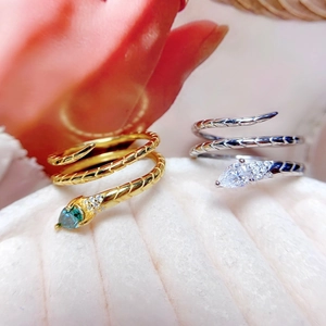 Macro shot of snake-shaped rings with pear-cut gemstones and bionic scale textures